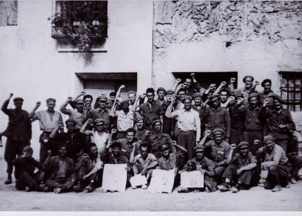 A photograph of several dozen Canadian volunteers in the Abraham Lincoln Battalion, with their fists raised in a gesture of solidarity.